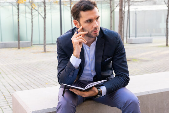 Serious businessman with notebook on street