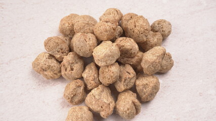 Raw soya chunks on dark background. Healthy, nutritious soybean meat, chunks isolated.Vegan food concept.
