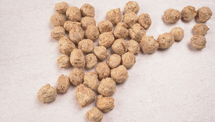 Raw soya chunks on dark background. Healthy, nutritious soybean meat, chunks isolated.Vegan food concept.
