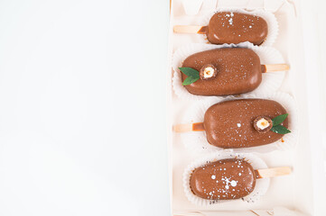 Chocolate cake pops in the form of ice cream on a stick. On a wooden stand, top view. Concept food, sweets.