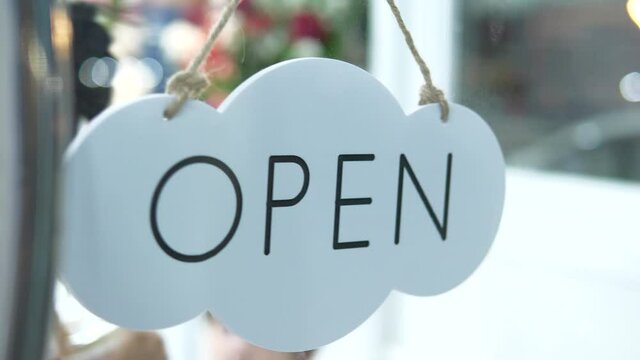 Small Business Owner Opening Shop With "OPEN" Sign on Glass Door

