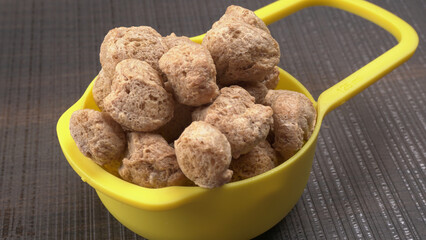 Raw soya chunks on dark background. Healthy, nutritious soybean meat, chunks isolated.Vegan food concept.
