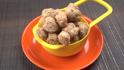 Raw soya chunks on dark background. Healthy, nutritious soybean meat, chunks isolated.Vegan food concept.
