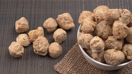 Raw soya chunks on dark background. Healthy, nutritious soybean meat, chunks isolated.Vegan food concept.
