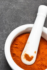 Ground paprika in ceramic mortar and pestle.