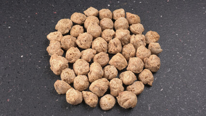 Raw soya chunks on dark background. Healthy, nutritious soybean meat, chunks isolated.Vegan food concept.