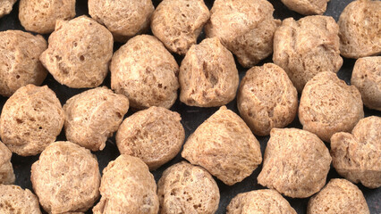 Raw soya chunks on dark background. Healthy, nutritious soybean meat, chunks isolated.Vegan food concept.