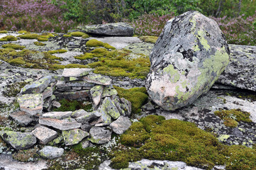 Naklejka na ściany i meble Circle of rocks with moss in mountain area. Big boulder to the right of stone circle. Horizontal photo.