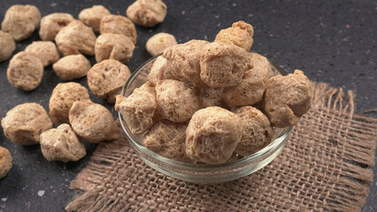 Raw soya chunks on dark background. Healthy, nutritious soybean meat, chunks isolated.Vegan food concept.