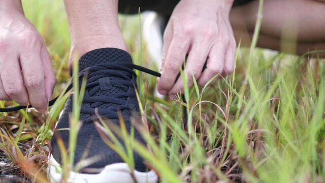 Athlete Tying Shoelaces on Running Track Preparing for Training or Competition