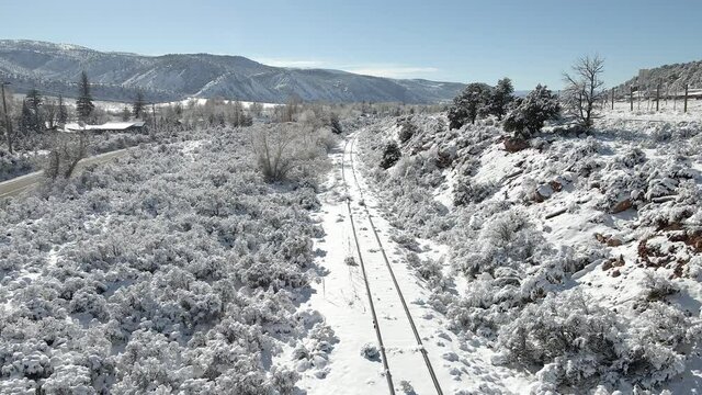 Flying along unused train tracks with fresh snow and rising to see part of Interstate 70. Filmed in the Rocky Mountains of Colorado between Eagle and Avon along Interstate 70.