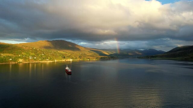 A super cool cinematic HD shot of the beautiful Loch Broom Ullapool while the sun going down over the Summer Isles in the far north west coast highlands of Scotland with a boat on the pleasant island.