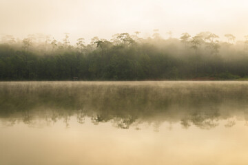 Obraz na płótnie Canvas View of sunrise over the lake in nation park, Beautiful rainforest landscape with fog in morning, Thailand.