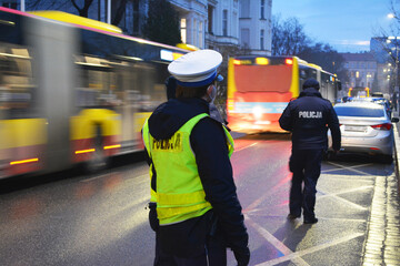 Policjanci ruchu drogowego polskiej policji w mieście podczas kontroli ruchu pojazdów. w odblaskowej kamizelce. 
 - obrazy, fototapety, plakaty
