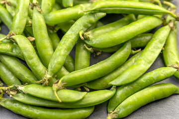Close up photo green pods of fresh just ripped off peas. Vegetable background. Legumes.
