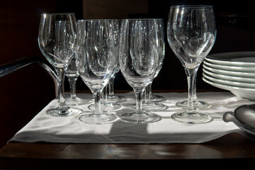 Wine glasses and plates on the table in the sunlight
