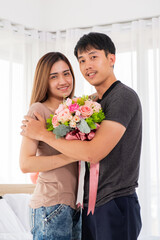 The girlfriend is glad to recieve a bouquet of flowers from her boyfriend which embrace her with love.