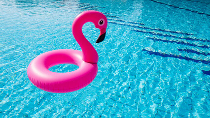 Pink pool. Pink inflatable flamingo in water for summer beach background. Funny bird toy for kids. © Maksym