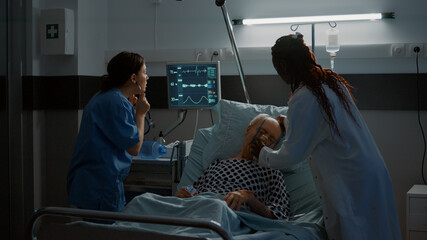 African american doctor placing oxygen tube on patient in hospital ward at medical reanimation...