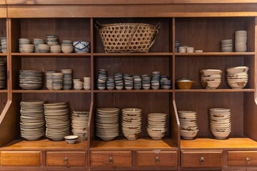 Kitchenware with dishware keeping on kitchen wooden shelving.Traditional Vietnamese blue porcelain...