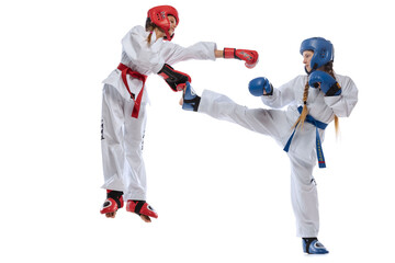 Sportive young girls, teens, taekwondo athletes training together isolated over white background. Concept of sport, education, skills