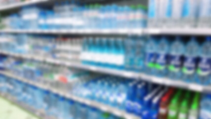 Abstract blur image of supermarket background. Defocused shelves with water bottles, food. Grocery shopping. Store. Retail industry. Rack. Discount price. Inflation and economic crisis concept. Aisle.