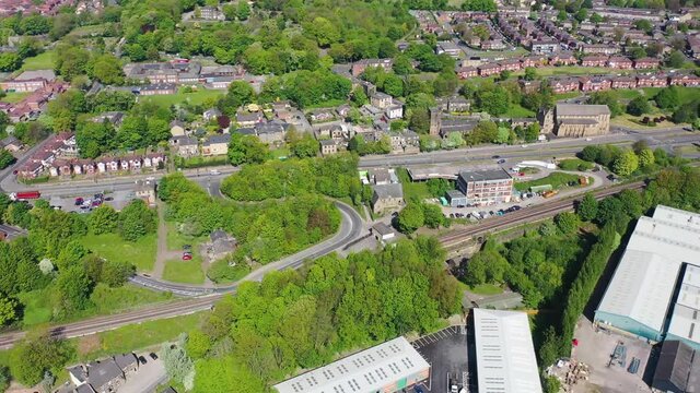 Aerial footage of the town centre of Dewsbury in West Yorkshire in the UK showing factories and buildings along side the the river calder on a summer summers day