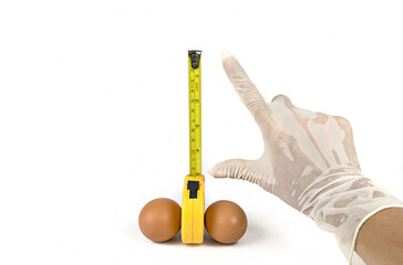 Chicken eggs,measuring tape and hand isolated on white background.Concept men penis size big and...