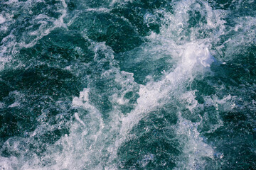 Fototapeta na wymiar White crest of a sea wave. Selective focus. Shallow depth of field.