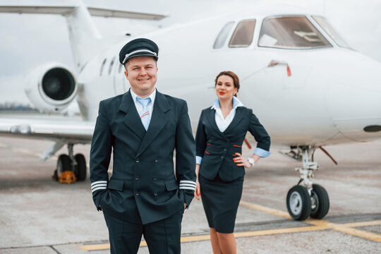 Man with woman. Aircraft crew in work uniform is together outdoors near plane