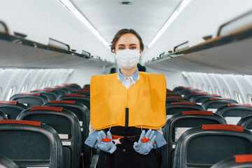 Safety instructions. Young stewardess on the work in the passanger airplane