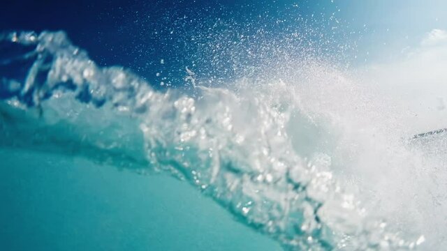 Underwater view of the rolling and breaking ocean wave and crystal clear water in Maldives