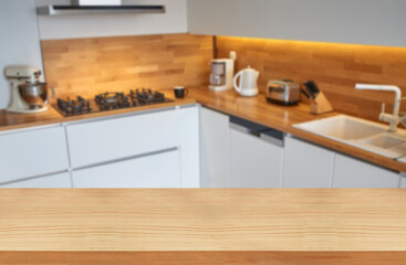 Empty wooden table top with blurred kitchen and cabinet background
