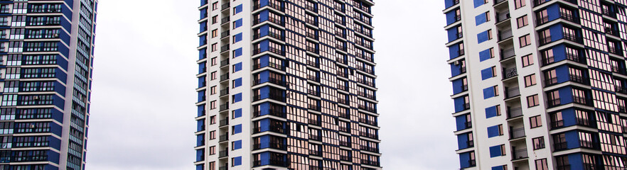 Fototapeta premium Three multi-storey buildings against the sky. Skyscrapers against the sky
