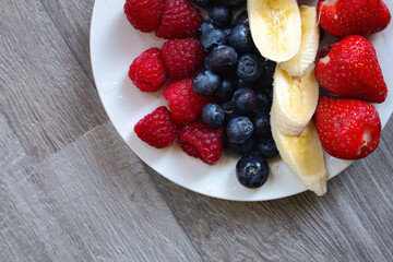 Healthy breakfast, Fresh fruits plate, Summer diet, Summer body, Strawberries, Bananas, Blueberries and Rasberries