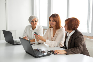 team of three successful adult women in the office	
