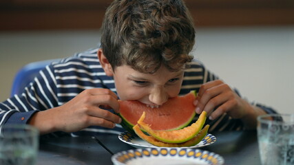 Young boy eating watermelon fruit