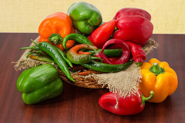Bell peppers and chilli different colors on a wooden table
