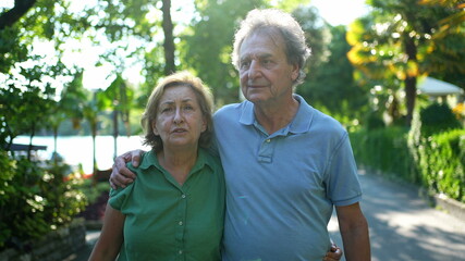 Senior couple walking together outdoors. 60s husband and wife walk