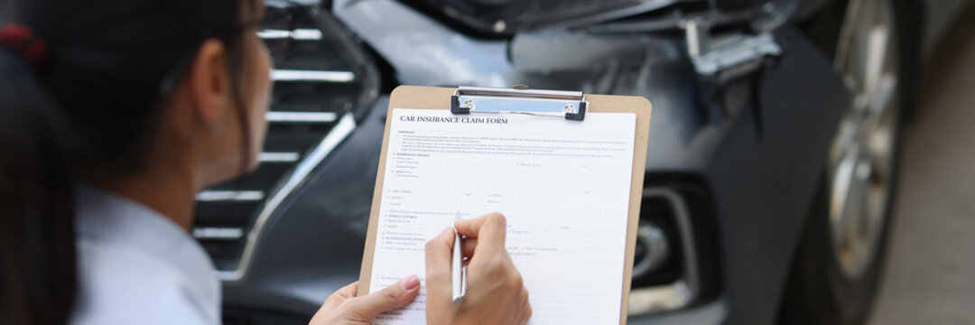Woman insurance agent fills out insurance form for car damage after traffic accident