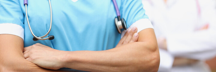 Fototapeta premium Two doctors stand confidently with folded hands closeup