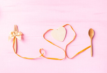 Couple spoon and fork with ribbon and heart shape on pink background, Valentine day concept