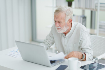 The senior elderly man work from home get confuse from work in a workplace room.