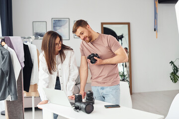 Photographers works indoors in their studio at daytime