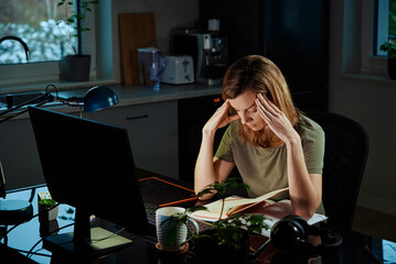 Woman works late at home workplace, remote work concept. Burnout and emotional stress due to...