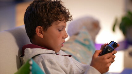 Little boy playing video-game indoors on tablet device © Marco