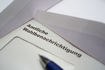 Black letters on white envelope saying: Official election notification (german: Amtliche Wahlbenachrichtigung). 2021 federal election in germany. 2 opened envelopes on the side. Diagonally view.