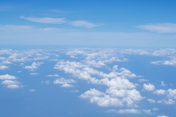 Naklejka na ściany i meble Aerial view of clouds and sky seen through the airplane window