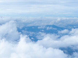 Scenic view of the mountains against fog, clouds, and a blue sky