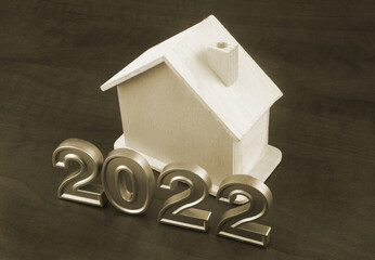 Wooden house and numbers 2022 on table, real estate and house price in 2022 concept.	